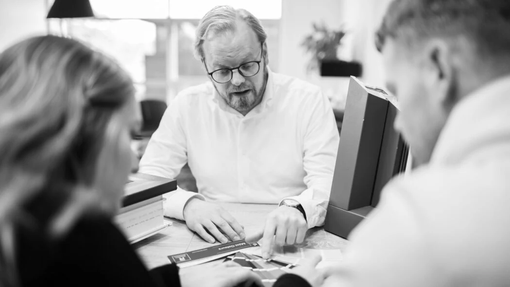 Drei Personen besprechen gemeinsam Unterlagen an einem Tisch